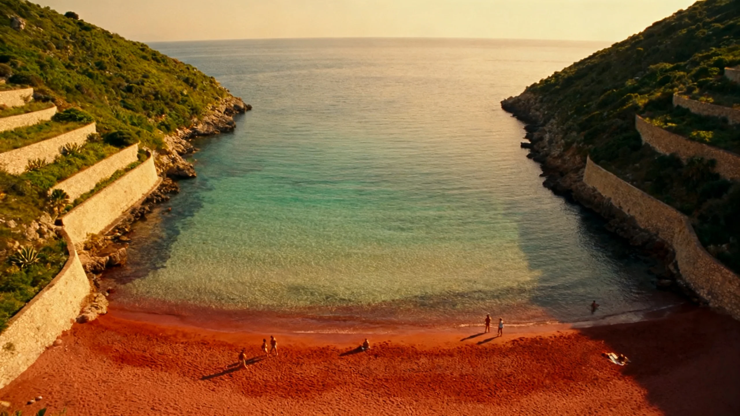 Ramla Bay at golden hour, with the red sand and the green hillsides framing the empty bay